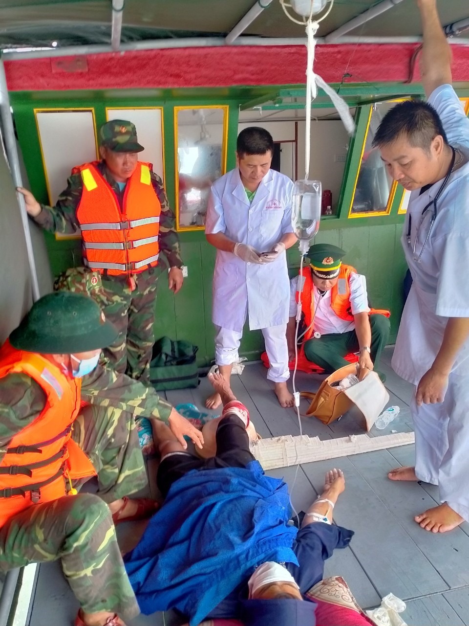 Người đàn ông bị cá mập tấn công được các chiến sĩ biên phòng tới đưa đi cấp cứu. Ảnh: Lao động
