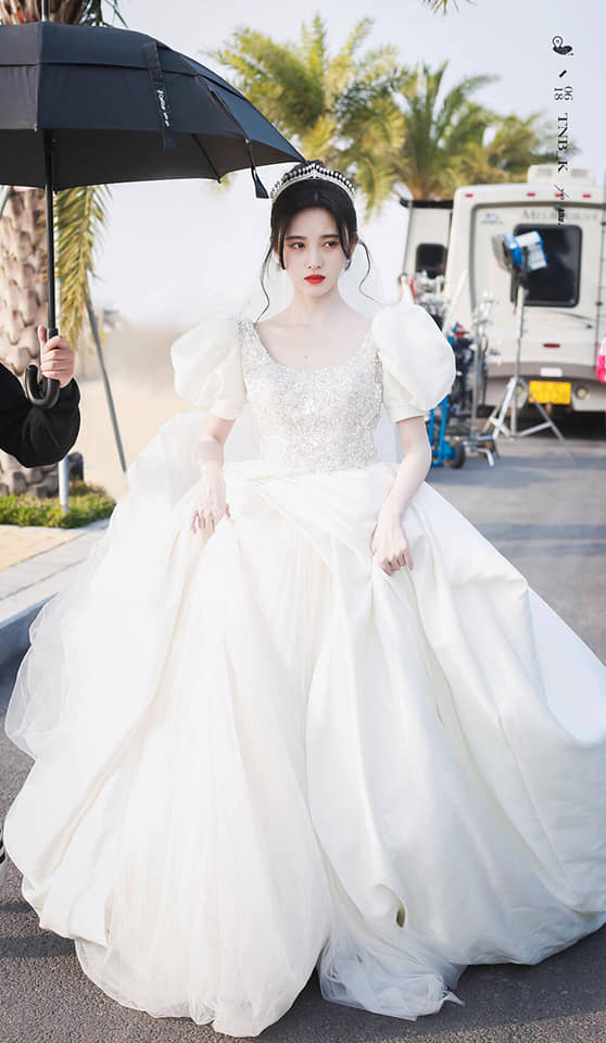 Cúc Tịnh Y hóa thân thành công một nàng công chúa ngọt ngào. Thiết kế cầu vai tạo nên tổng thể kiêu sa, cô nàng không quên đội vương miện, đánh son đỏ để visual ấn tượng hơn