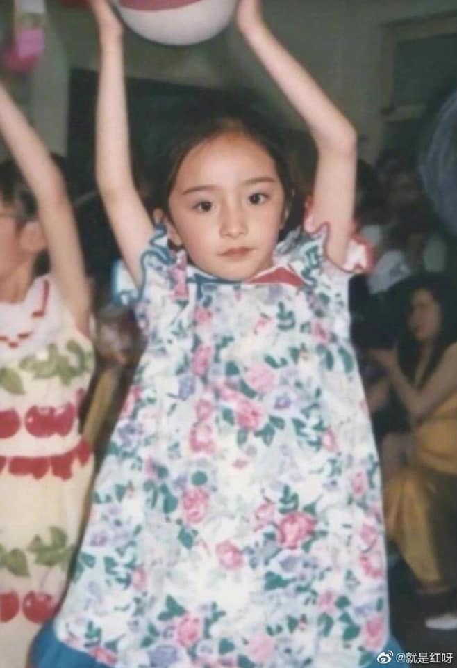 Cô bạn Dương Mịch ướm cánh đồng hoa lên người, ngay từ nhỏ vóc dáng của nữ minh tinh đã vô cùng mảnh mai, cánh tay dài thon gọn. Đôi mắt to chắc chắn là dấu hiệu nhận biết đầu tiên