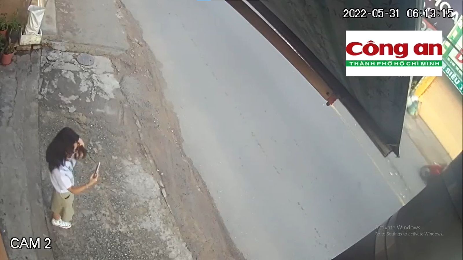 Nữ sinh lớp 9 đứng trước hiên nhà, sử dụng điện thoại Iphone 13 để soi gương, chỉnh trang trước khi đi học...