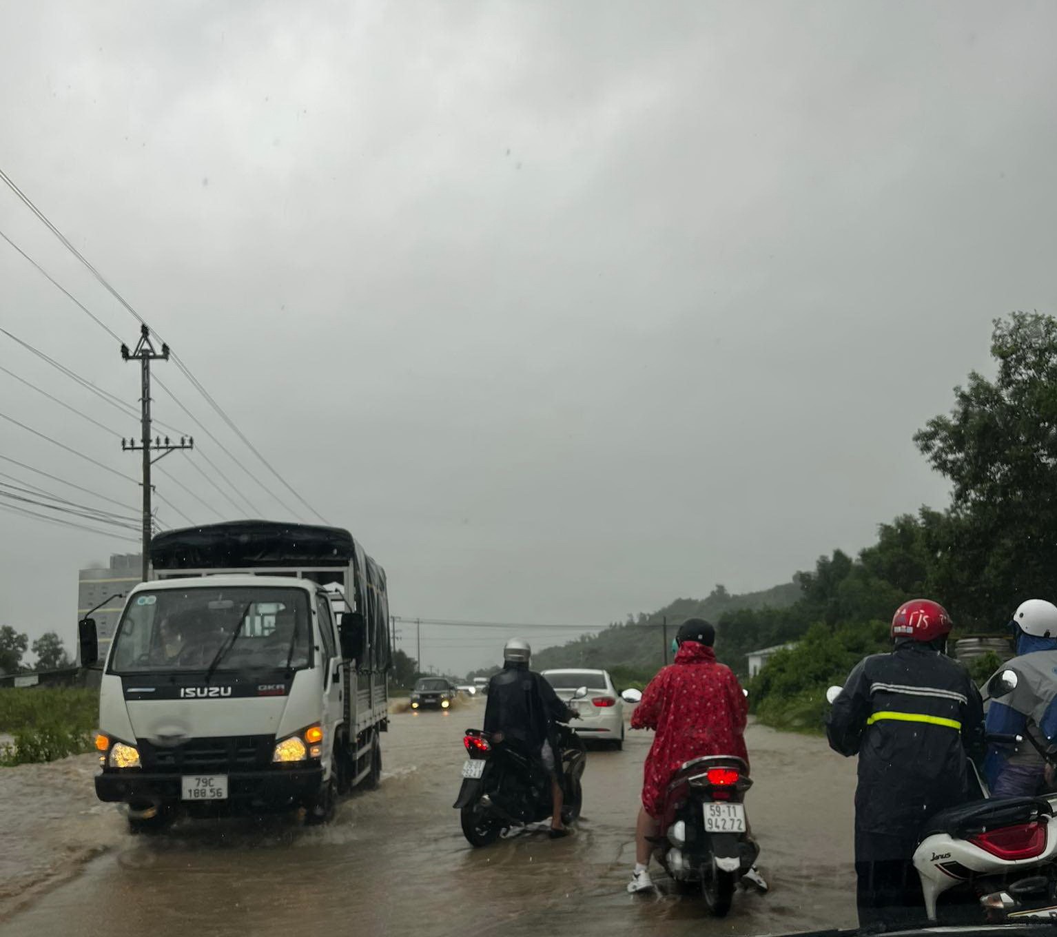 Nước tràn qua đường tại quốc lộ 27C đoạn qua xã Diên Thọ, huyện Diên Khánh, tỉnh Khánh Hòa khiến người dân đi lại khó khăn. Ảnh: Ngọc Thoa.