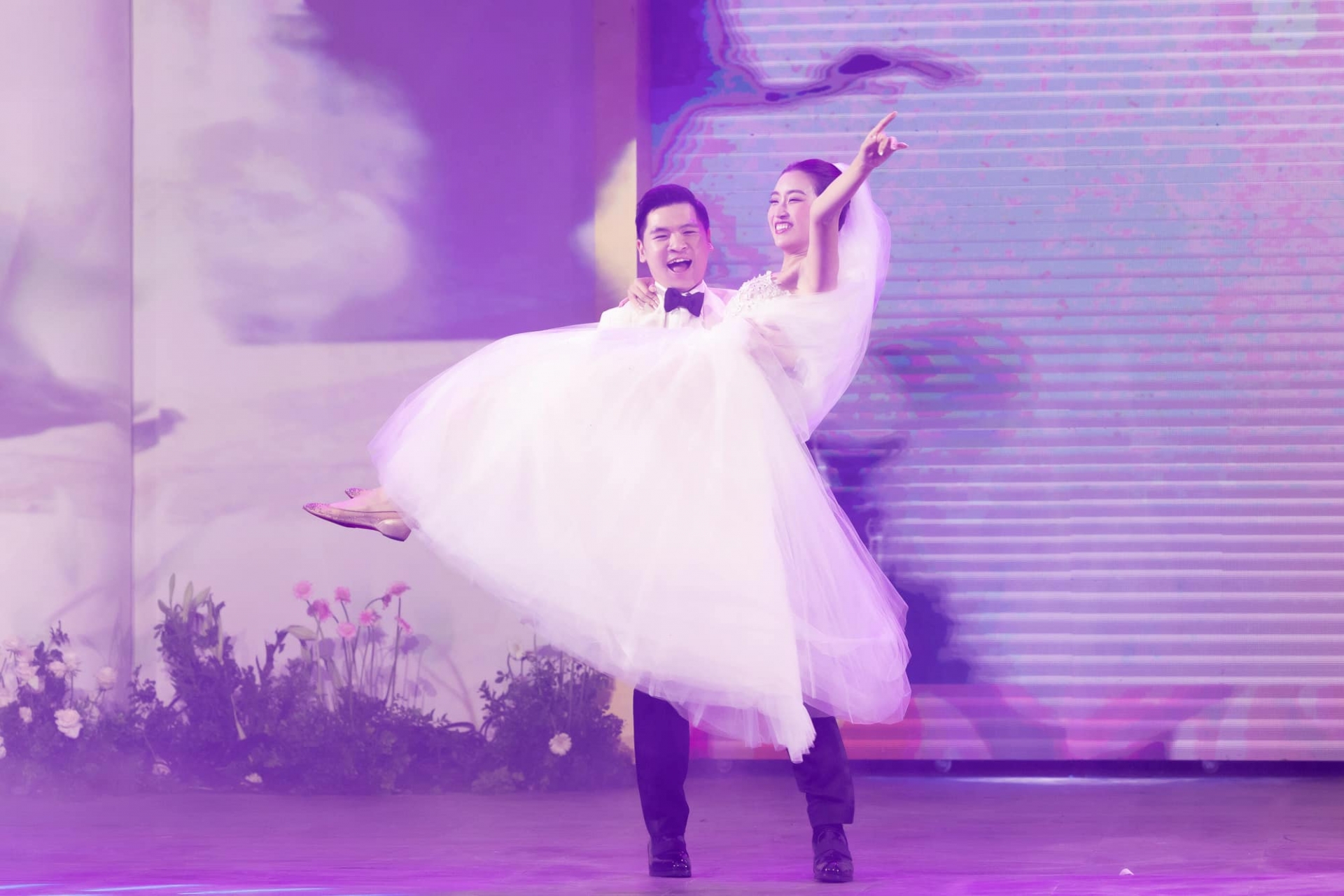 Chú rể hài hước nhấc bổng cô dâu Đỗ Mỹ Linh, gương mặt nàng hậu tỏ ra rất thích thú