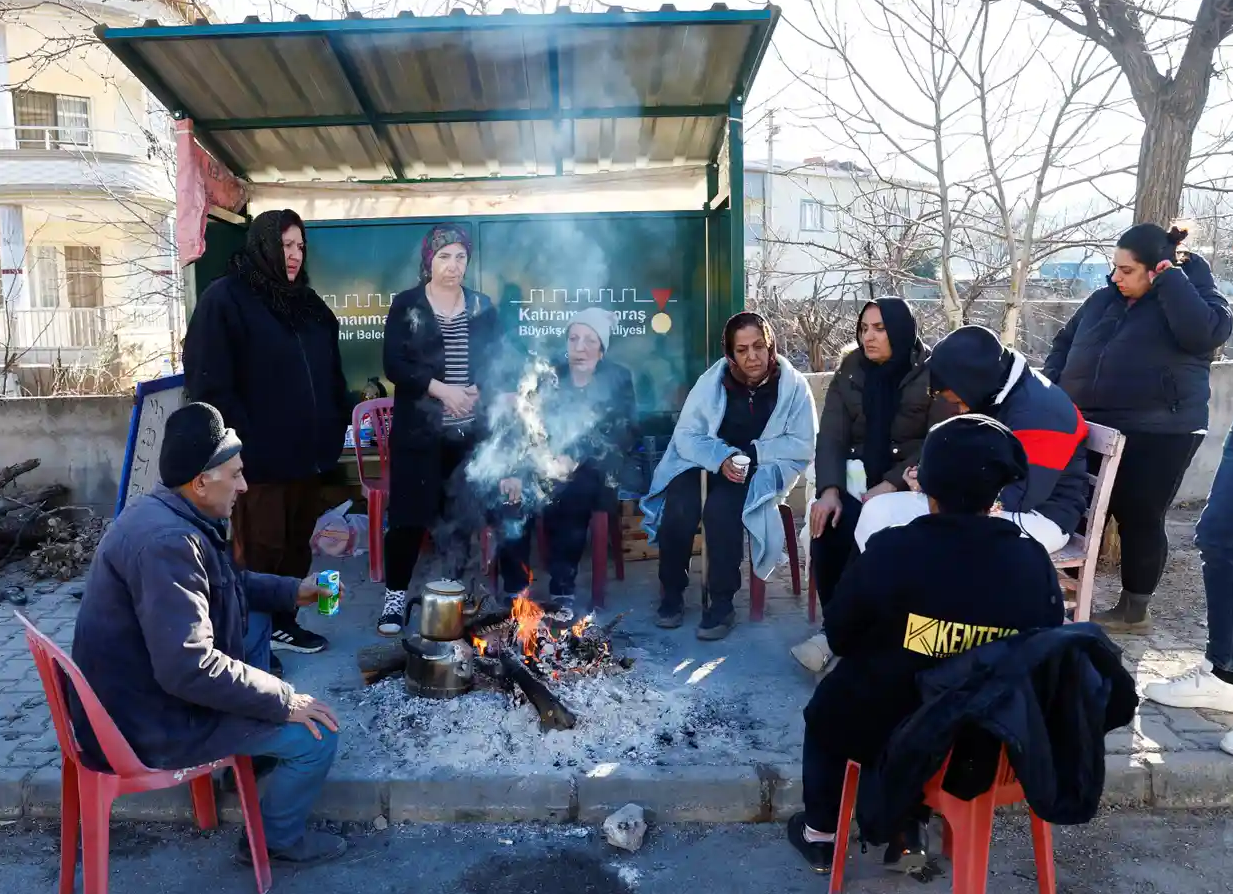 Mọi người sưởi ấm quanh đống lửa ở Pazarcık, tỉnh Kahramanmaraş, Thổ Nhĩ Kỳ. Ảnh: The Guardian