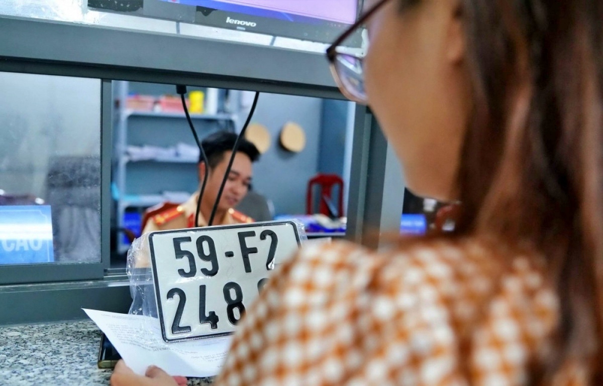 Cán bộ CSGT làm thủ tục đăng ký, thay đổi thông tin phương tiện cơ giới cho người dân.