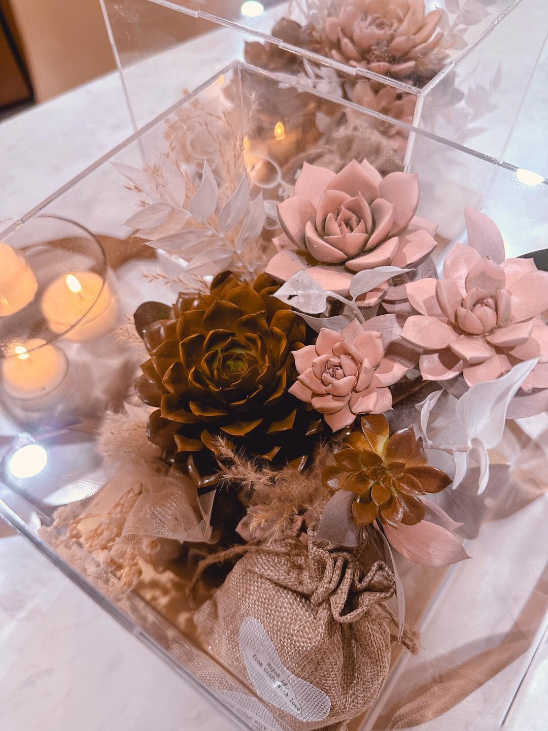 Thiệp được đặt trong một chiếc hộp trong suốt, bên trong bao gồm sen đá thật 100% và nến thơm handmade