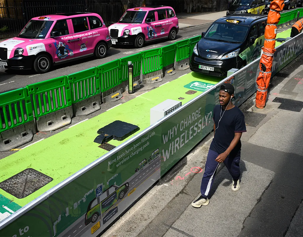 Một người đàn ông đi ngang qua dãy xe taxi có miếng sạc điện không dây vào ngày 18 tháng 8 năm 2022 tại Nottingham, Vương quốc Anh. Ảnh: Leon Neal/Getty Images