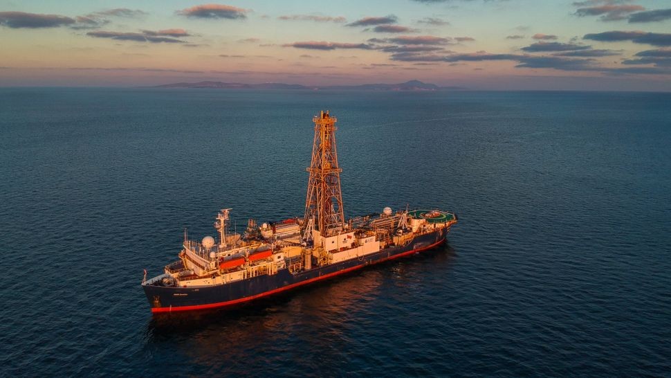 JOIDES phía bắc núi lửa Santorini (phía xa). Con tàu này là tàu khoan sâu nghiên cứu dài 460 feet (140 m) và cao 200 feet (60 m). (Ảnh: Thomas Ronge)