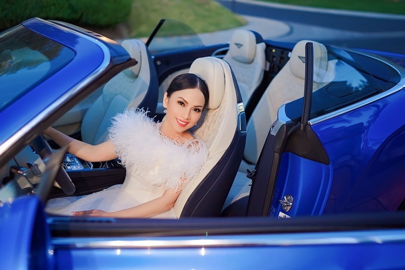 Em gái Cẩm Ly diện đầm tua rua trắng, thể hiện phong cách thanh lịch rất hợp với chiếc Bentley Coupe màu xanh, với giá khoảng 20 tỷ đồng. Em gái Cẩm Ly diện đầm tua rua trắng, thể hiện phong cách thanh lịch rất hợp với chiếc Bentley Coupe màu xanh, với giá khoảng 20 tỷ đồng.