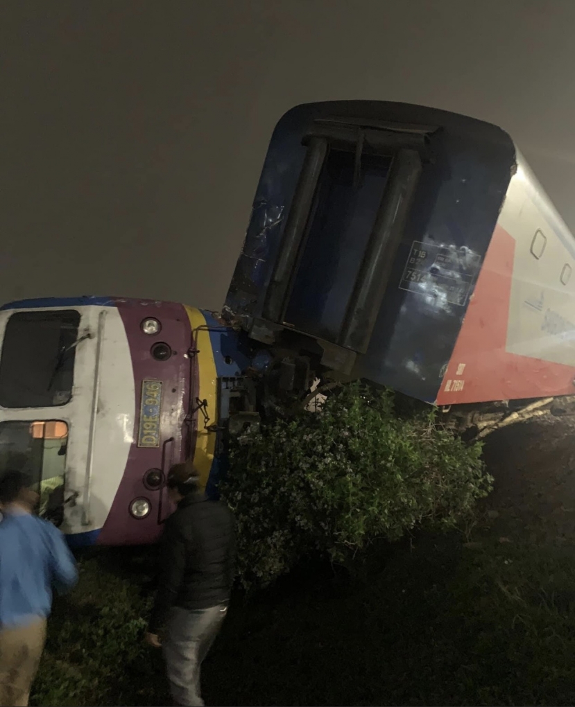 Sau cú va chạm, đầu máy tàu SE4 bị đổ nghiêng, 2 toa xe phát điện và hành lý tiếp nối đầu máy bị trật bánh nằm vắt chéo với đường ray. Ảnh: CTV Sau cú va chạm, đầu máy tàu SE4 bị đổ nghiêng, 2 toa xe phát điện và hành lý tiếp nối đầu máy bị trật bánh nằm vắt chéo với đường ray. Ảnh: CTV