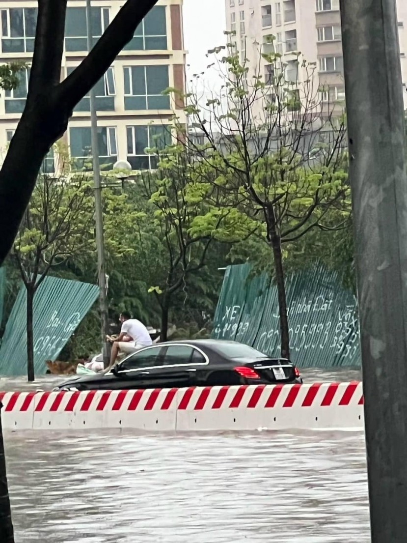Sự thật về bức ảnh người đàn ông ngồi trên nắp capo Mercedes chụp ảnh giữa biển nước tại Hà Nội - Ảnh 1 Sự thật về bức ảnh người đàn ông ngồi trên nắp capo Mercedes chụp ảnh giữa biển nước tại Hà Nội - Ảnh 1