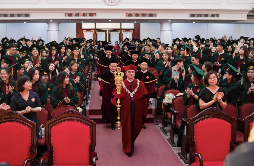 Hình ảnh hiệu trưởng trường ĐH Kinh tế (ĐH Quốc gia Hà Nội) mặc áo nhung, đeo vòng cổ và cầm quyền trượng trong lễ tốt nghiệp gây nhiều tranh cãi. Ảnh: Internet Hình ảnh hiệu trưởng trường ĐH Kinh tế (ĐH Quốc gia Hà Nội) mặc áo nhung, đeo vòng cổ và cầm quyền trượng trong lễ tốt nghiệp gây nhiều tranh cãi. Ảnh: Internet